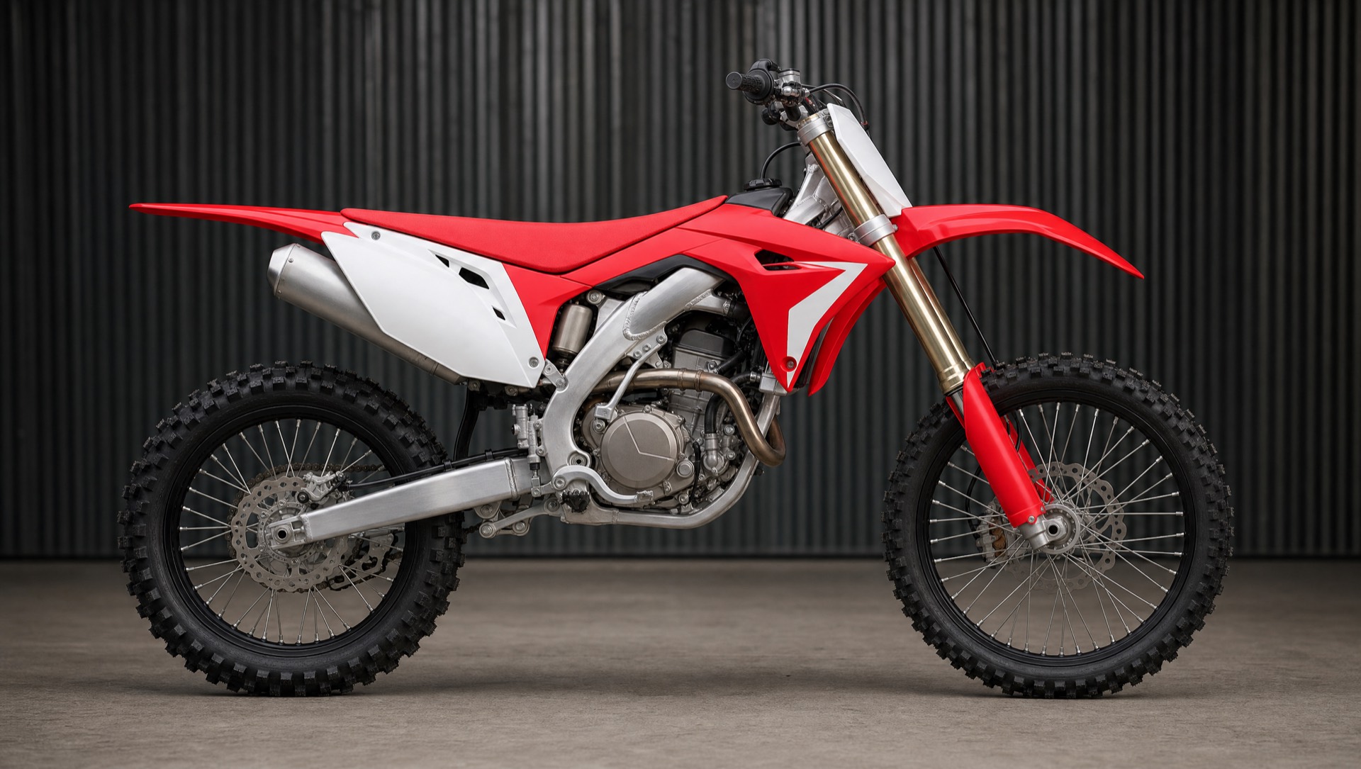 Moto de cross 250 rouge et blanche vue de profil dans un atelier.